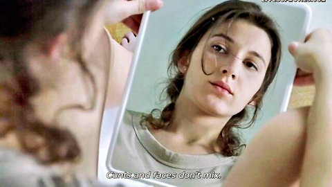 Brunette woman holding mirror to face, text 'Cunts and faces don't mix' from Romance X movie