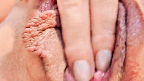 Closeup of babe spreading her wet puffy pussy lips with fingers exposing pink vagina