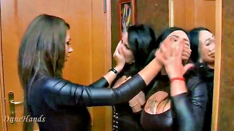 Busty brunettes in shiny leather hand gag young woman's mouth in elevator domination
