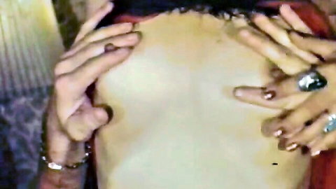 Retro close-up of red-nailed hands spreading pale bare ass cheeks