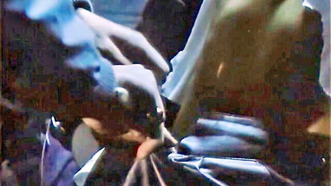 Female executioner in blue gloves handling mysterious device
