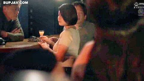 Busty Japanese MILF with huge tits in low-cut top holds drink at bar flirting with men
