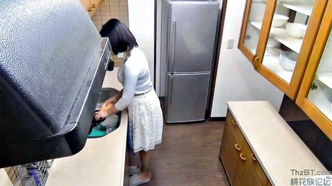 Japanese mature woman in skirt washing dishes in kitchen