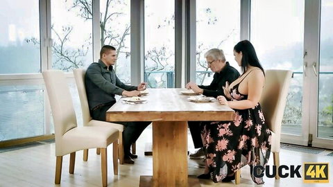 Busty brunette wife in floral dress at dinner with older husband and young friend