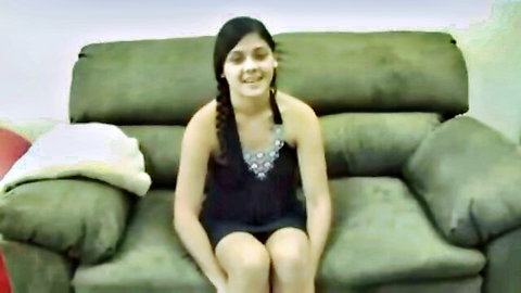 Innocent Latina teen with braids smiling in short black dress