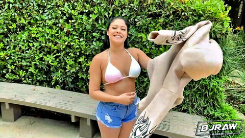 Serena Santos in pink bikini top and denim shorts, teasing outdoors