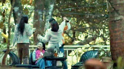 Group of clothed Asian women casually gathering and chatting in lush outdoor garden
