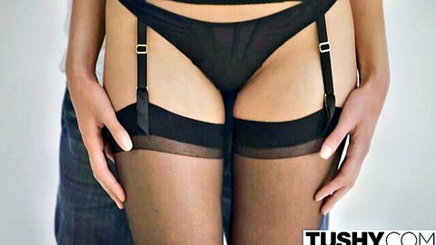 Man's hands gripping woman's sheer black panty-clad pussy and garter stockings