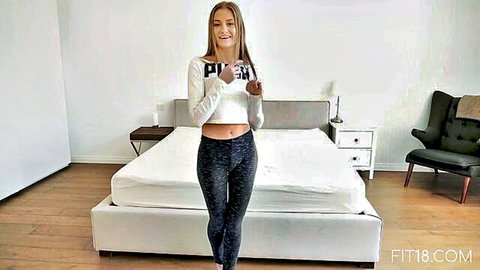 Tiffany Tatum in white crop top and black leggings, posing fit and flirty