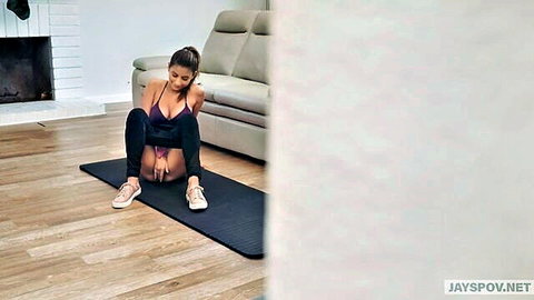 Nina North in sexy purple top and shorts, seductive yoga pose with cleavage