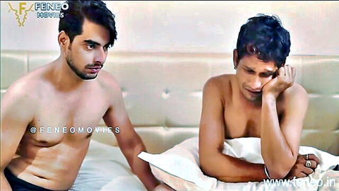 Two shirtless Indian muscular men on bed in intimate emotional scene