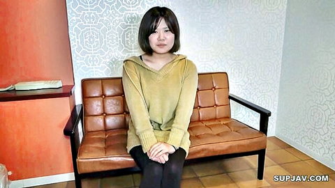 Japanese woman in beige hoodie and black pants sitting on couch, amateur JAV solo