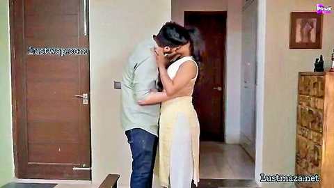 Indian couple in passionate embrace, woman in white saree kissing man