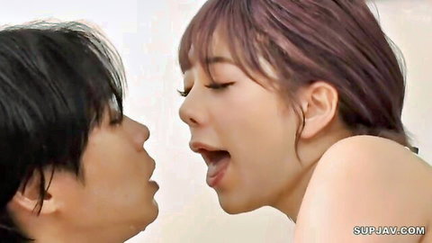 Asian couple in close intimate kiss, wet-haired woman nude upper body