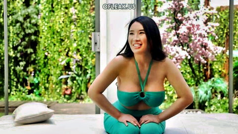 Busty Asian Suki Miki smiling in sexy green halter top and shorts