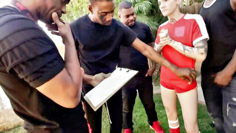 Tattooed blonde in red tracksuit surrounded by black men in interracial gangbang scene