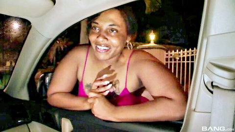 Sugar Hill smiling from car window in pink top, black street hooker vibe