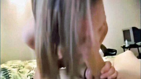 Mature blonde MILF bent over bed gripping sheets with hand on her bare ass from behind
