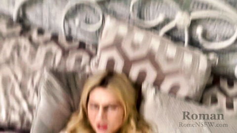 Blurry blonde with glasses in ecstatic orgasm face mouth wide open on bed.