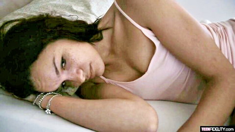 Edin Sin in pink camisole, lying on bed with sultry gaze for deep creampie scene