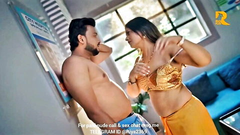 Indian couple in intimate scene, busty woman in gold blouse and orange skirt embracing shirtless man