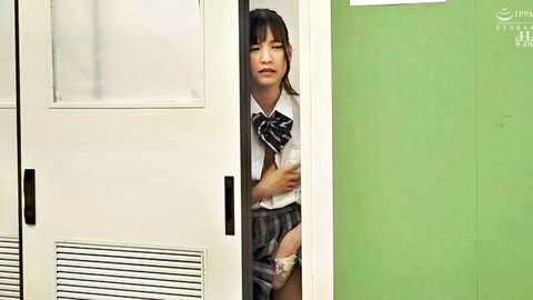 Japanese schoolgirl in uniform peeking shyly from bathroom door