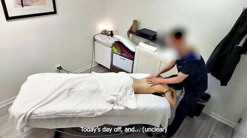 Masseur hands massaging petite East Asian babe's bare back and perfect ass on massage table