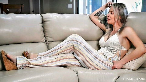 Tattooed MILF with long blonde hair lounging in sexy crochet top