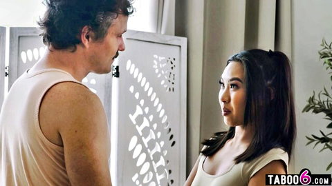Hairy older man in tank top stares intensely at petite East Asian girl's cleavage in low-cut dress