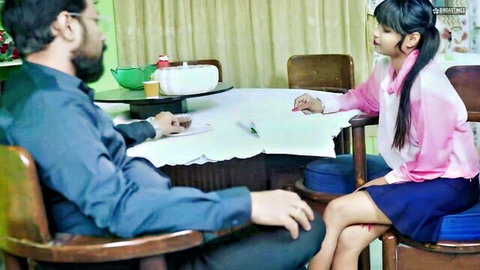 Indian stepdad in blue shirt talks to young stepsister in pink hoodie and short blue skirt at kitchen table