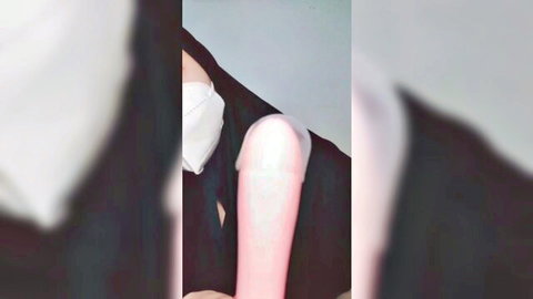 Veiled Arab woman in hijab inserts thick dildo under black robe while masked
