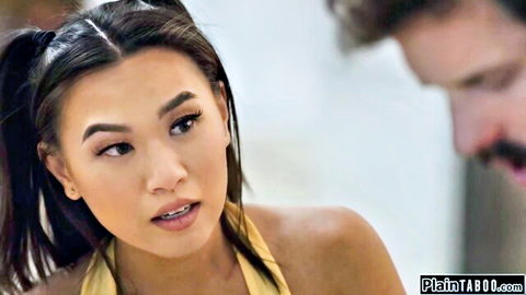 Young petite Asian with pigtails in yellow halter top showing cleavage seductively