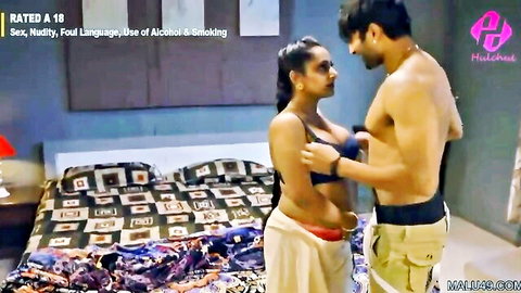 Muscular shirtless Indian stud gropes big tits of brunette babe in black bra from behind in bedroom
