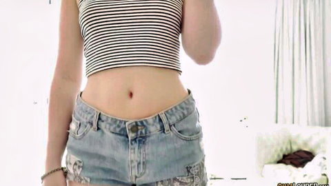 Slim babe teasing in striped crop top and low-rise ripped jeans exposing navel and hips
