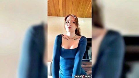 Pale freckled redhead with tattoos teases deep cleavage in tight blue top