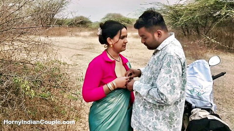 Indian couple in sari and shirt sharing intimate moment outdoors near scooter