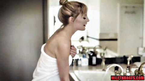 Blonde MILF in white towel admiring herself in steamy bathroom mirror