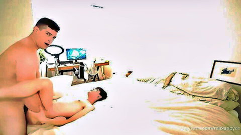 Muscular naked stud grabs leg of glasses twink on bed ready for gay anal fuck