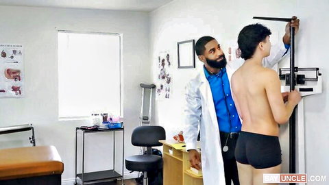 Black doctor measuring height of shirtless Asian patient in briefs during exam
