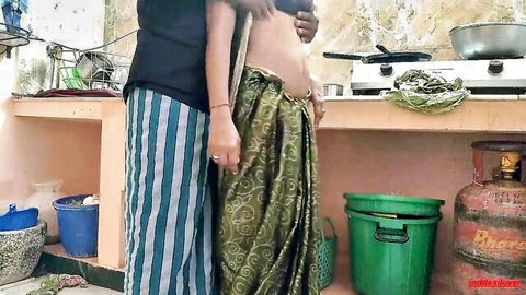 Pregnant Indian woman in green saree embraced from behind by man