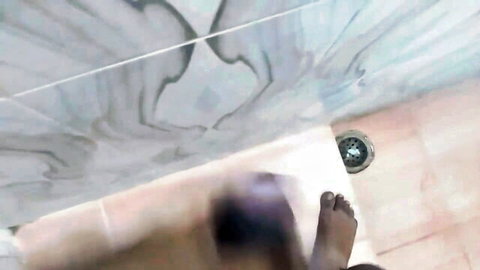 Blurry amateur bathroom handjob scene with visible foot and lower body