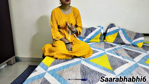 Saara Bhabhi in yellow Indian dress sitting seductively on bed