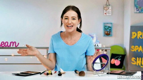 Aubree Valentine smiling in blue V-neck top at makeup vanity, POV tease
