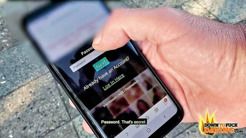 Hand holding phone with RealFuckingDating.com login screen, adult dating app teaser