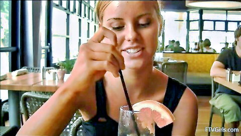 Sensual blonde babe teasingly sucking straw in mouth at restaurant table