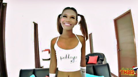 Cute smiling Thai teen with pigtails in tight white Thaigirl tank top showing midriff
