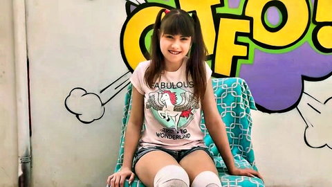 Luna Rival smiling playfully in fabulous t-shirt, short shorts and thigh-high socks