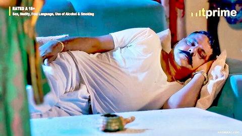 Mature fatty Indian man lounging relaxed in white shirt on couch