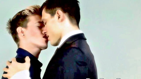 Two skinny young gay twinks passionately kissing while dressed in suits