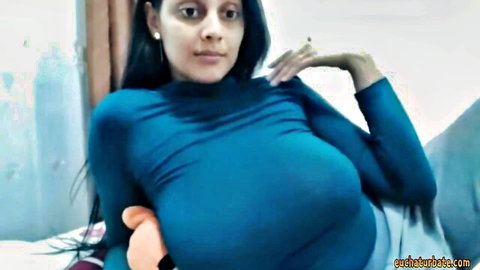 Busty Indian MILF with massive tits in tight blue sweater smoking seductively on webcam